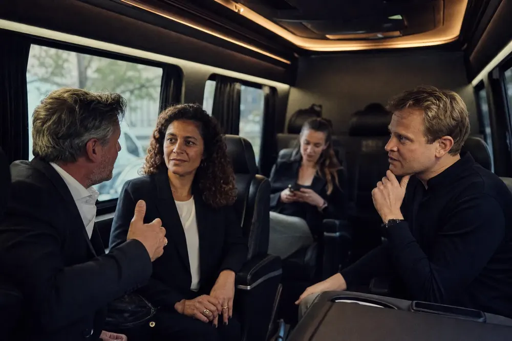 Convention attendees boarding a black executive Sprinter for a Convention Center transfer