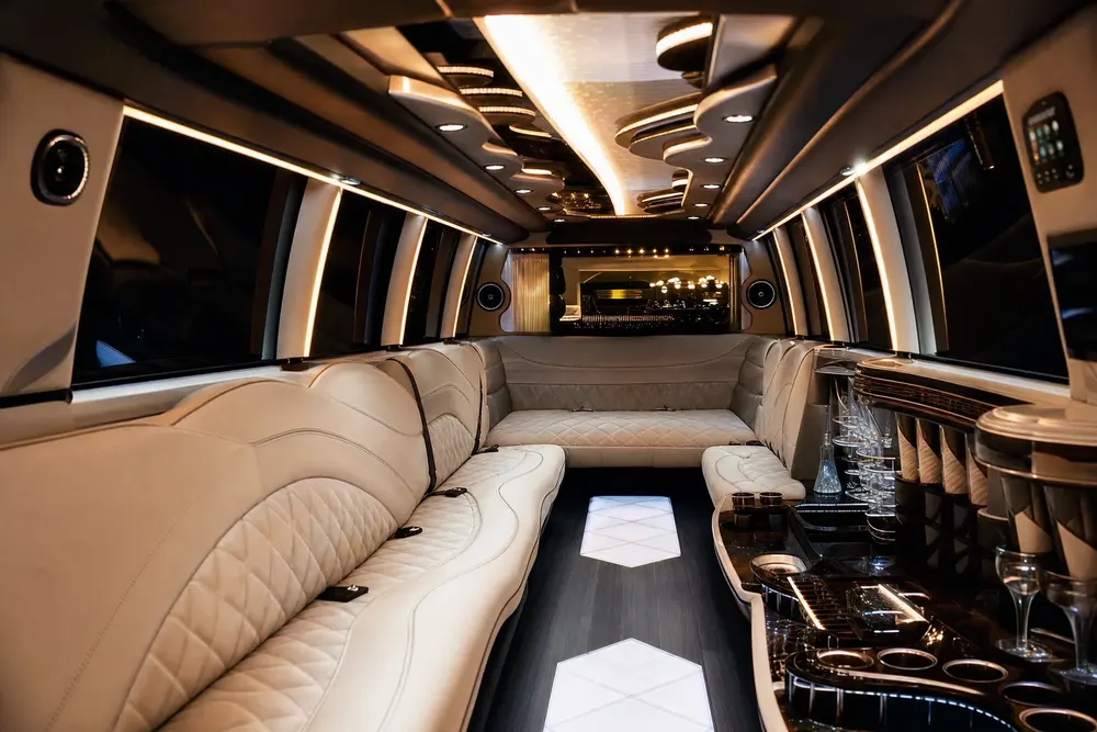 Wrap-around white leather lounge and star ceiling in the Escalade Stretch cabin